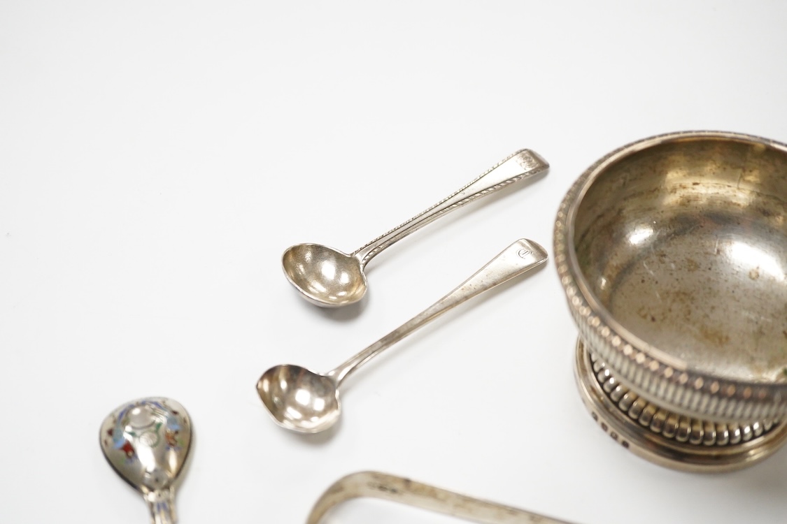 A George III silver pedestal salt, London, 1805, diameter 84mm, together with a pair of Georgian silver sugar tongs, two silver condiment spoons and a Russian 84 zolotnik and polychrome cloisonne enamel spoon, 11.1cm.